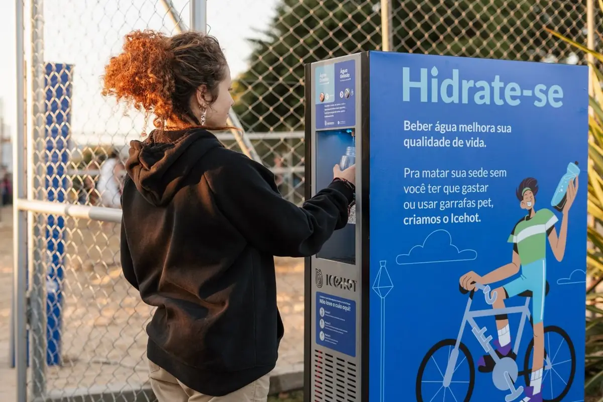 Pessoa enchendo a garrafa numa estação