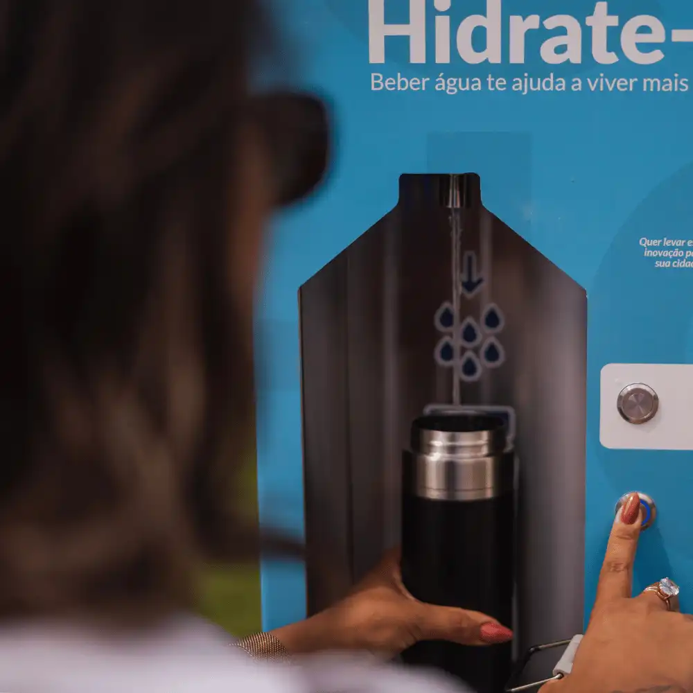Garrafa sendo enchida no dispenser da estação