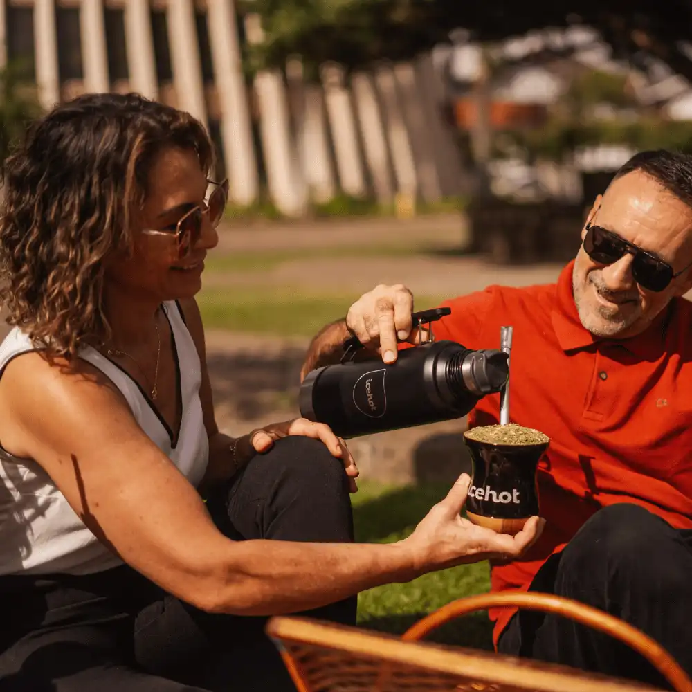 Casal servindo chimarrão na praça