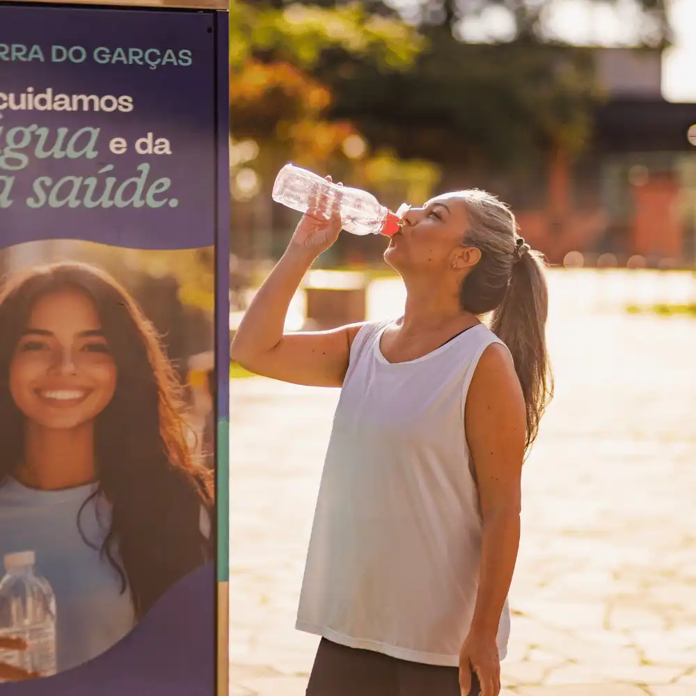 Mulher bebendo água da garrafa perto da estação