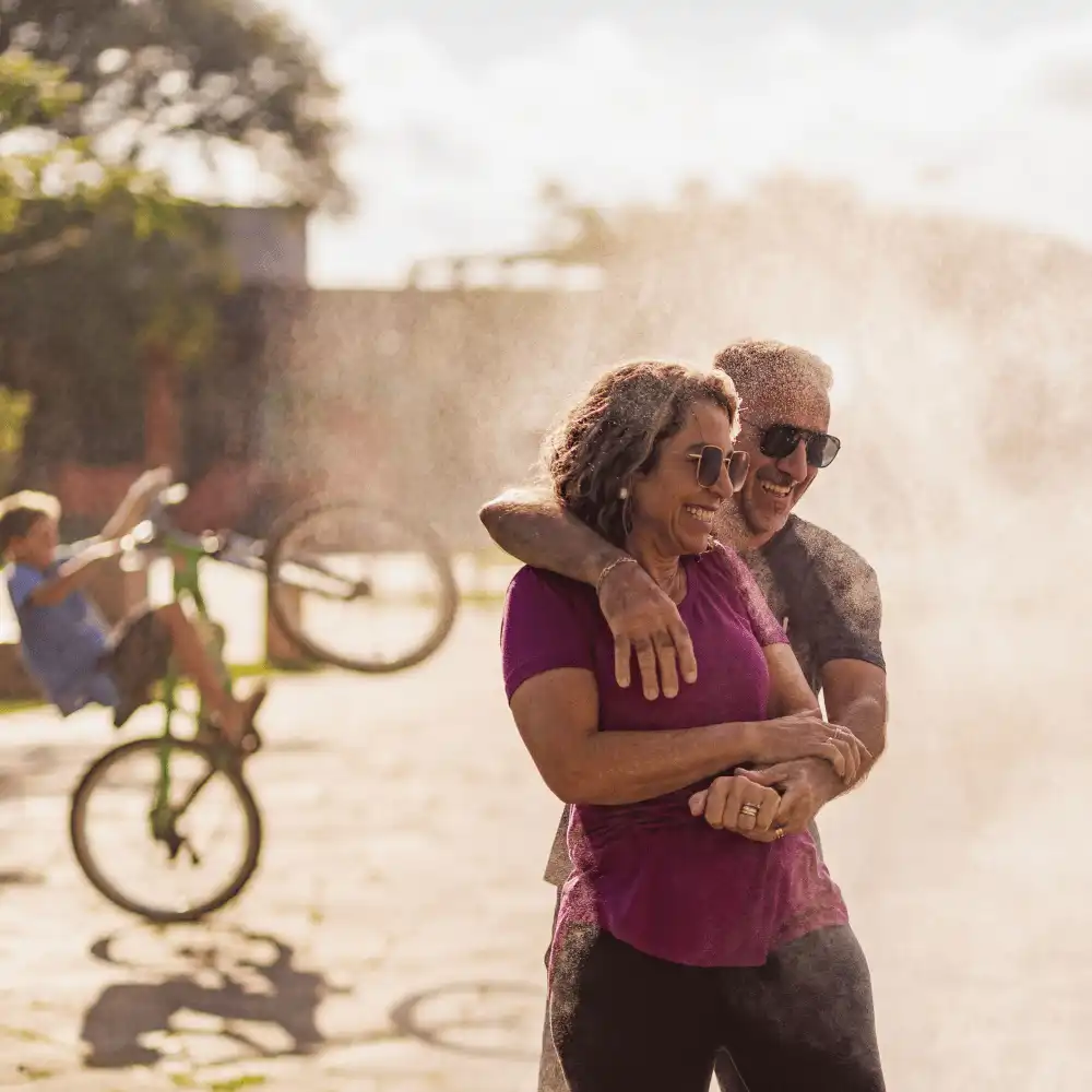 Casal abraçado perto da névoa, com ciclista ao fundo
