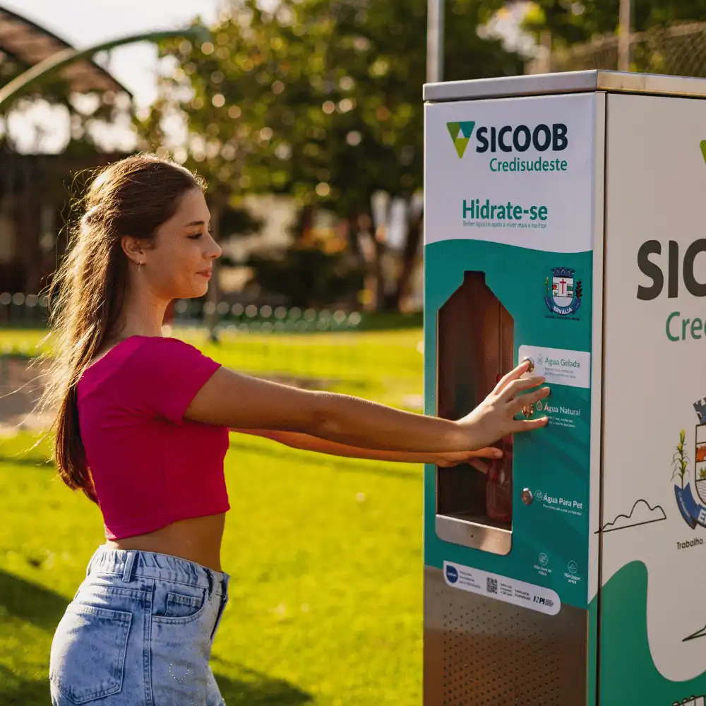 Jovem enchendo a garrafa numa estação Sicoob