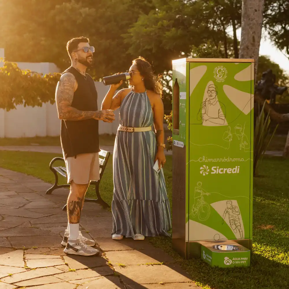 Casal ao lado de uma estação Sicredi