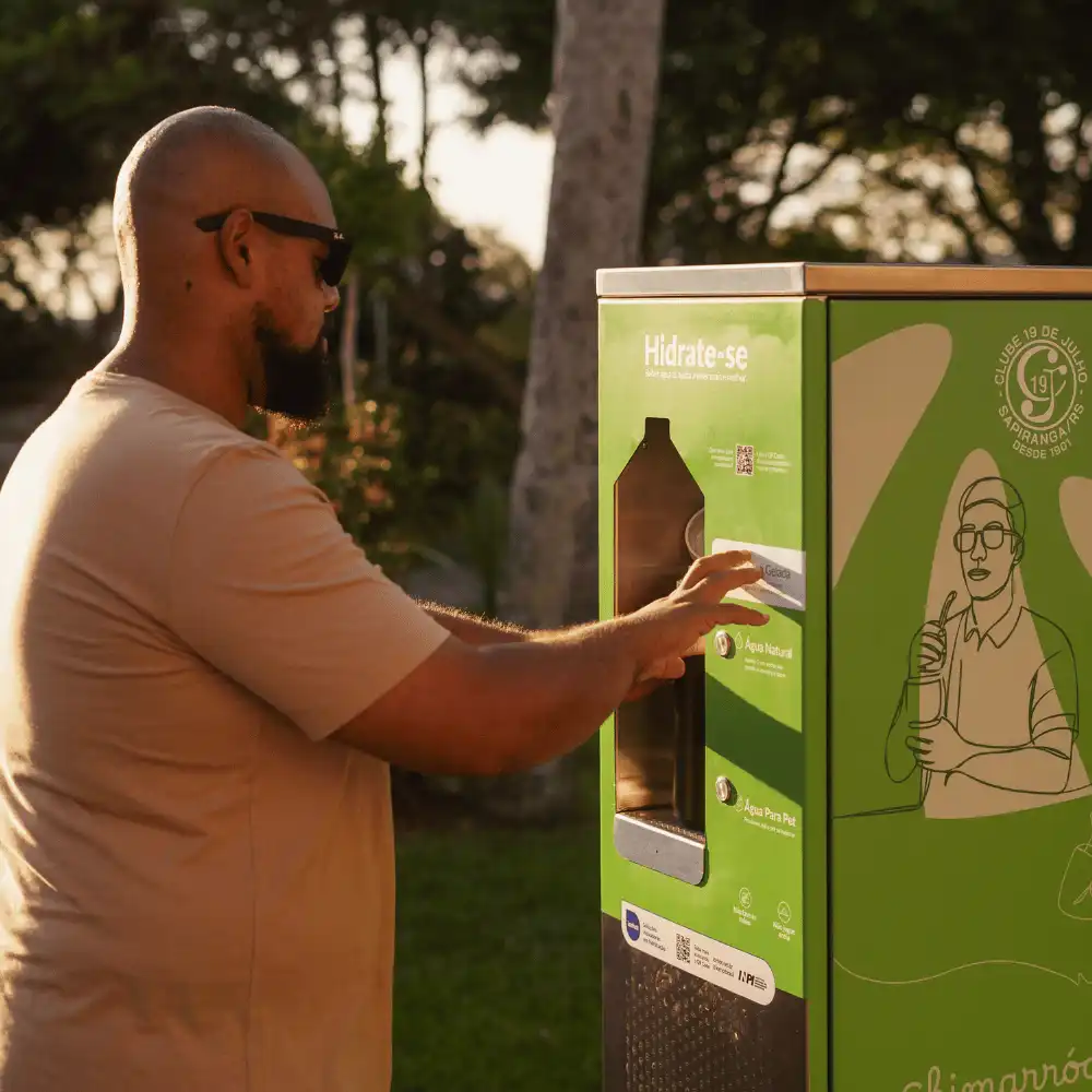 Homem usando o dispenser de uma estação Sicredi