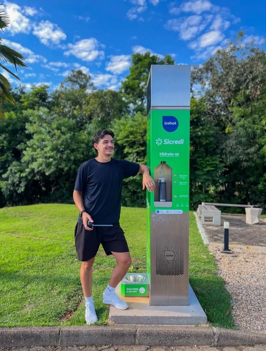 Homem ao lado de uma estação Sicredi num parque